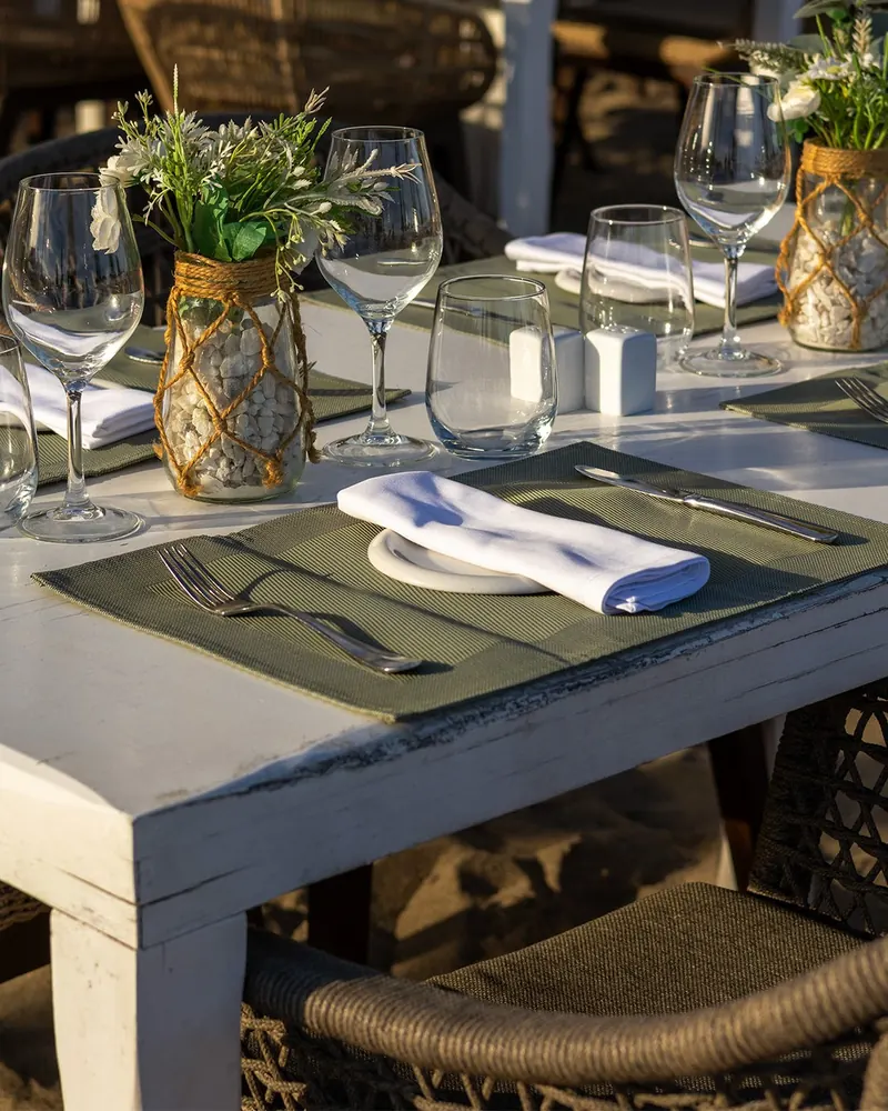 A laid table at Camurí Las Cuchis with flowers and glassware